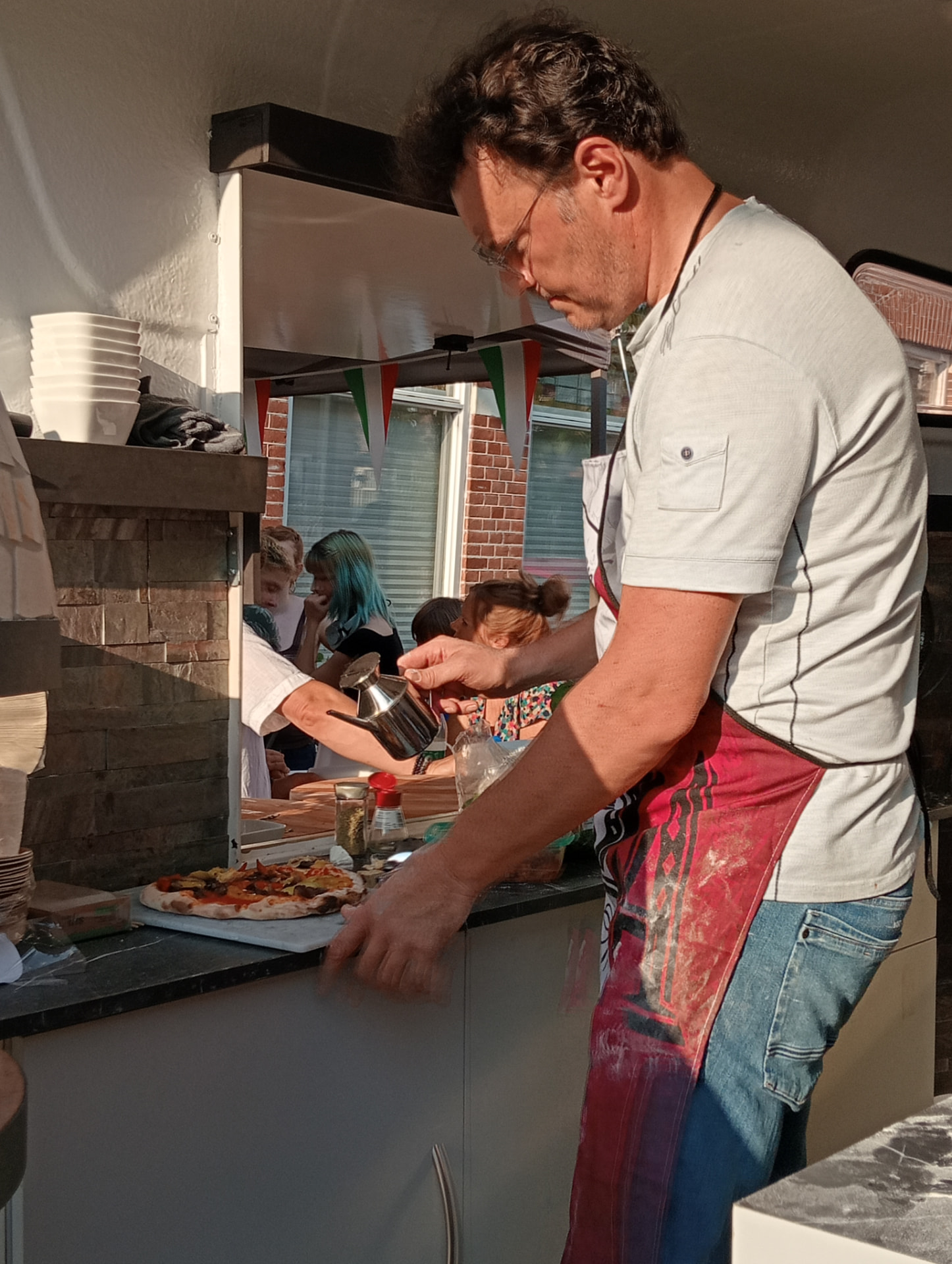Frans bezig met een pizza in de pizzatrailer