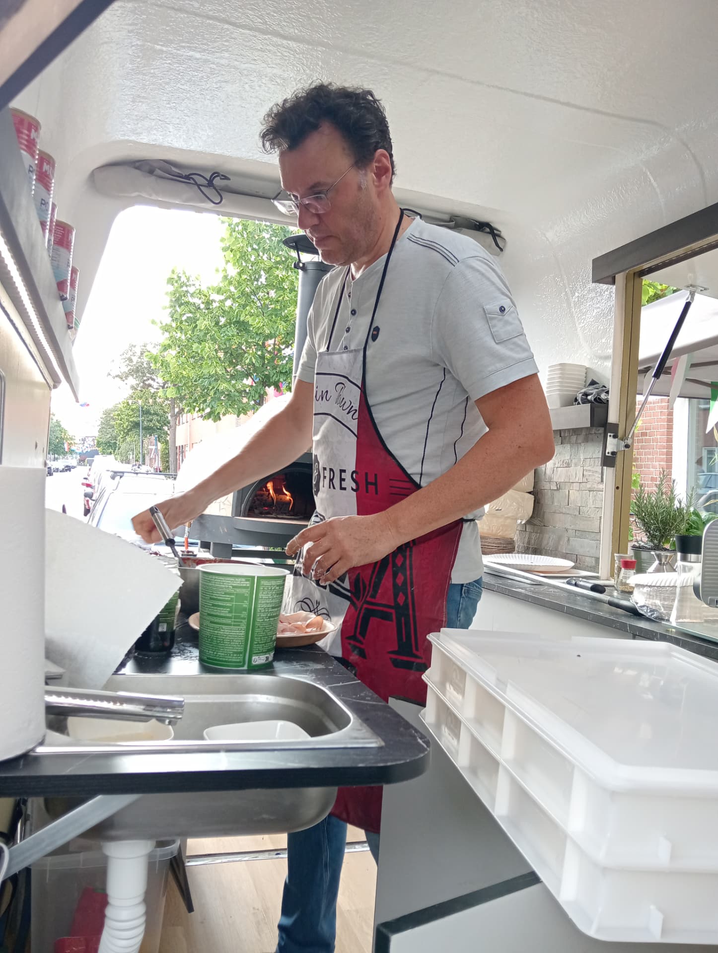 Frans bezig met het bereiden van pizza in de pizzatrailer
