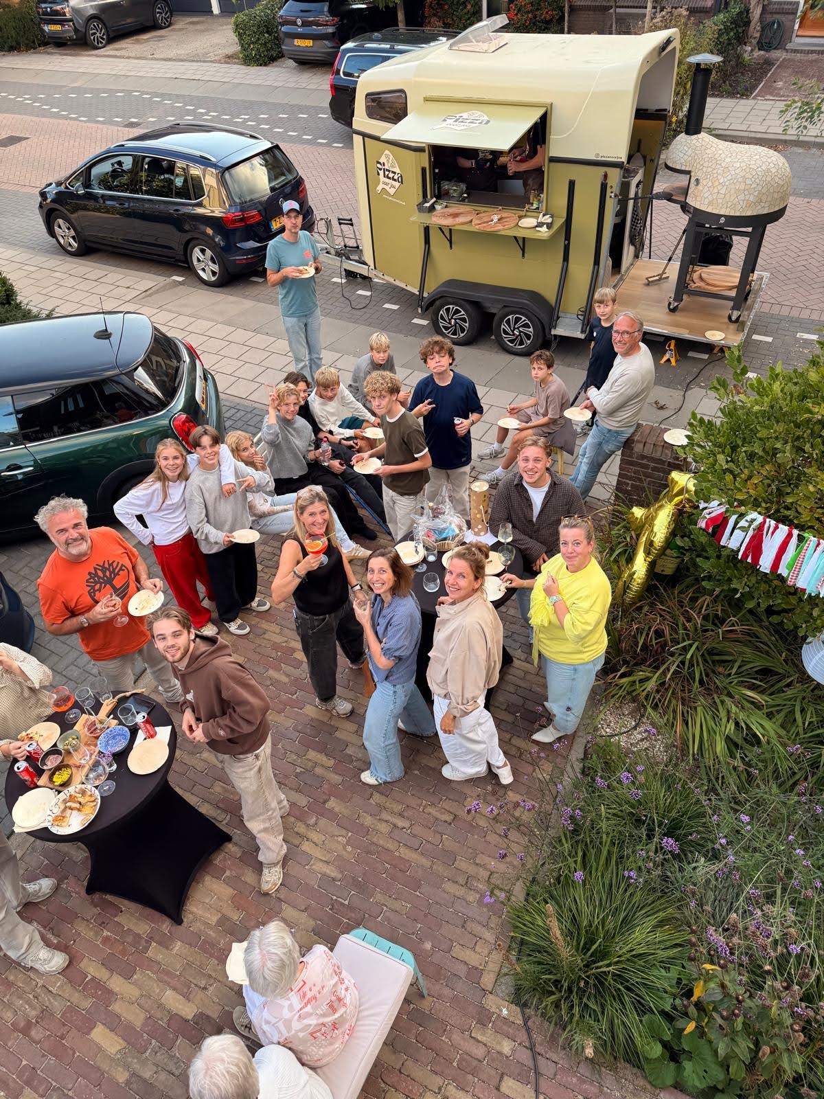 Gasten van bovenaf gefotografeerd rond de pizzatrailer van Pizza voor jou in Gouda