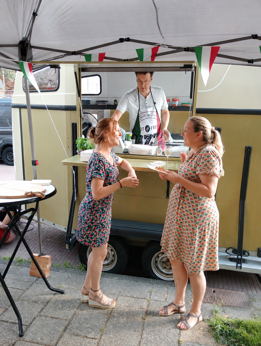 Gasten met pizza voor de pizzatrailer van Pizza voor jou